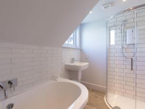 a white bathroom with a tub and a sink at Marchbourne in St Ives +37 photos