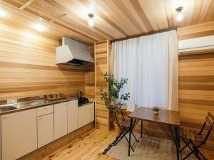 cocina con paredes de madera, mesa y ventana en Noasobi Lodge 202- Vacation STAY 23084v, en Arao