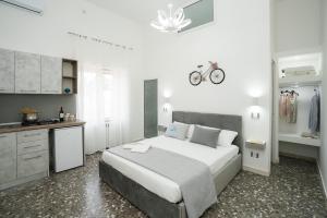 a white bedroom with a large bed and a kitchen at Meraviglia d'Otranto in Otranto