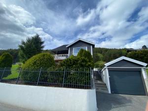 a house with a fence and a garage at Sukkertoppen Apartment in Ålesund