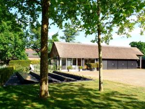 una casa con un edificio con árboles delante en B&B de Scherpenhof en Leur