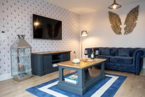 a living room with a blue couch and a table at The Old Doghouse in York