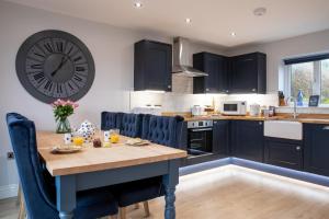 a kitchen with a table and a clock on the wall at The Old Doghouse in York