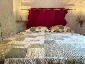 a bedroom with a bed with a red wall at Maison charmante à La Roche-sur-le-Buis avec piscine partagée in La Roche-sur-le-Buis +9 photos