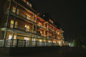 un grand bâtiment avec des lumières allumées la nuit dans l'établissement Grand Hotel Strand, à Vyšné Ružbachy