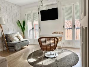 sala de estar con mesa y silla en Apartamentos Succo, en Plasencia