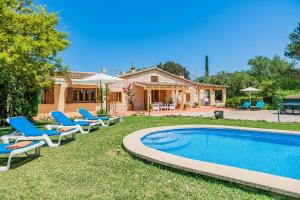 um quintal com piscina e cadeiras e uma casa em Villa Jaume Crestatx By SunVillas Mallorca em Sa Pobla