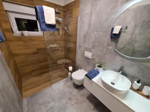 a bathroom with a toilet and a sink and a shower at Apartments & Rooms Tom in Medulin +30 photos