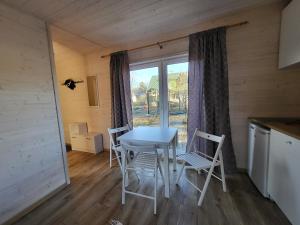 uma mesa e cadeiras num quarto com uma janela em Mamma maja em Haapsalu