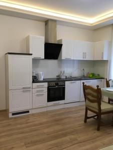 a kitchen with white cabinets and a table and a chair at Apartment Top Diplomat in Prague