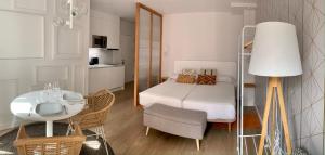 Habitación pequeña con cama, mesa y silla en Apartamentos Succo, en Plasencia