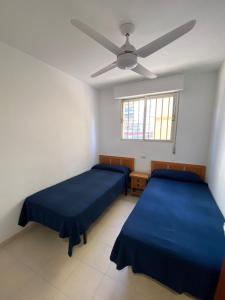 1 Schlafzimmer mit 2 Betten und einem Deckenventilator in der Unterkunft ED. MISTRAL VIDABER in Oropesa del Mar