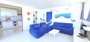 a living room with two blue couches and a table at Puerto San Telmo Beach in Puerto de la Cruz