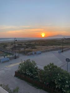 a sunset over a parking lot with the sun setting at Apartamento a pie de playa in Tarifa