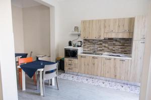 a kitchen with wooden cabinets and a table with chairs at La Farfalla in Favignana