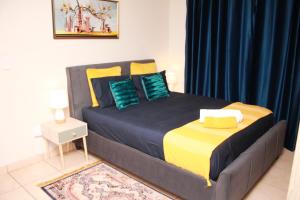 a bedroom with a large bed with blue and yellow pillows at 43 Home self Catering with backup power in eMalahleni
