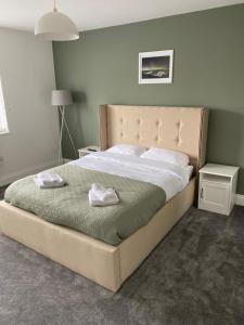 a bedroom with a large bed with two towels on it at Bridlington Shore Apartment in Bridlington