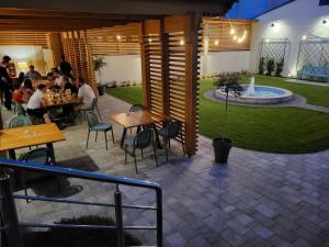 a patio with people sitting at tables and a fountain at Hotel Đakovo in Đakovo