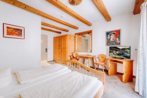 Schlafzimmer mit einem Bett, einem Schreibtisch und einem Tisch in der Unterkunft Hotel Nuss in Grainau