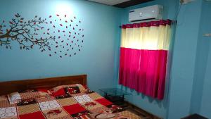 um quarto com uma cama e uma cortina vermelha e branca em Gharat Cottage em Alibaug