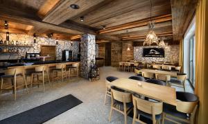 a restaurant with wooden walls and tables and chairs at Apartmany Demänovka in Demanovska Dolina