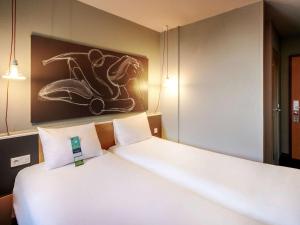 a hotel room with a large bed and a large mirror at ibis Strasbourg Centre Historique in Strasbourg