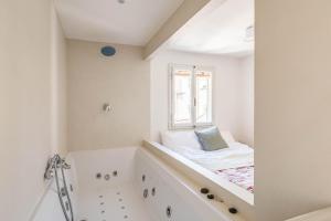 ein Bad mit Badewanne und ein Bett im Fenster in der Unterkunft Apartments Florence - Sprone Terrace in Florenz