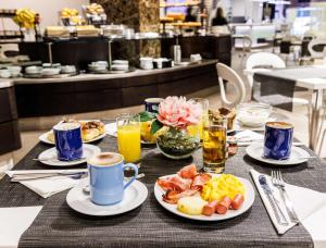 a table topped with plates of food and drinks at Best Western Premier Hotel Royal Santina in Rome