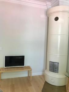 a room with a fireplace with a bench and a microwave at Old Turku Family Apartment in Turku