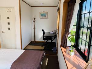 a bedroom with a bed and a desk and a window at Sunhouse - Vacation STAY 28595v in Yachimata