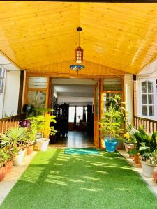 a porch with plants and a wooden ceiling at Sai Cottage Shimla in Shimla