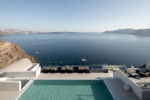 Hom Santorini في أويا: مسبح مع كراسي وإطلالة على الماء