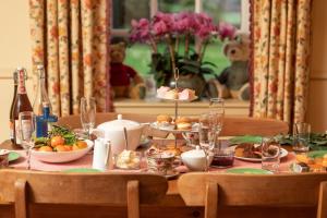 Kildary的住宿－Balnagown Estates Gardener's Cottage，桌子上摆放着食物和饮料的桌子