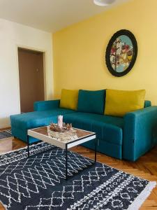 a living room with a blue couch and a coffee table at Skopje Cozy Apartment in Skopje