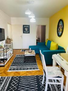 a living room with a blue couch and a table at Skopje Cozy Apartment in Skopje