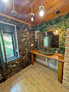 a bathroom with a sink and a stone wall at Cityside Cottage in Eger