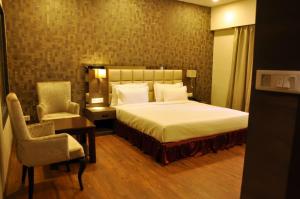 1 dormitorio con cama, escritorio y silla en KC MANOR, en Jamshedpur