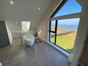 a bathroom with a tub and a large window at 5 Bedroom Cottage - Llyn Peninsula in Pistyll