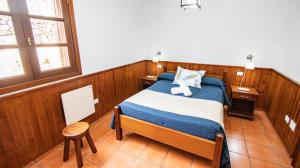 Un dormitorio con una cama con un osito de peluche blanco. en HolidaynorthTenerife Caserío Rural Los Charcos, en Icod de los Vinos