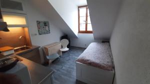 a small room with a bed and a sink at Studio 401 au 15 rue Battant à Besançon in Besançon