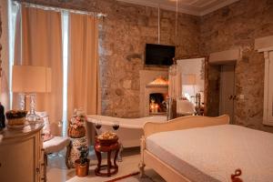 a bedroom with a bed and a tub and a fireplace at Hoşça kal Alaçatı in Alaçatı