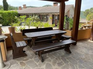 una mesa de picnic y un banco en un patio en Residenza Cerreto-Casalini, en Panicale