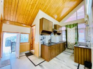 a kitchen with a wooden ceiling at Sai Cottage Shimla in Shimla