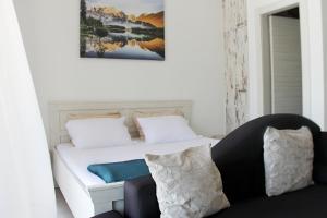 a bedroom with a white bed and a couch at Apartment Sunset in Kotor