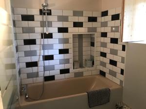 a bath tub in a bathroom with black and white tiles at Gîte Le Meynet in Saint-Cyprien +17 photos