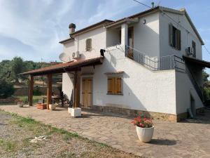 a white house with awning and a patio at La Maremmana in Talamone