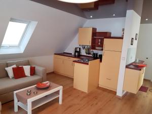 ein kleines Wohnzimmer mit einem Sofa und einer Küche in der Unterkunft Haus am Teich - Teichblick in Fehmarn