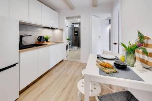 eine weiße Küche mit einem Tisch und einer Obstschale darauf in der Unterkunft CZAS NA GÓRY Jedlina-Zdrój. Apartament na 5 in Jedlina-Zdrój