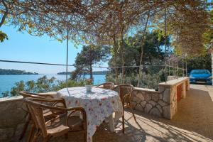 een tafel en stoelen met uitzicht op het water bij House Katarina with sea view and berth in Mali Lošinj