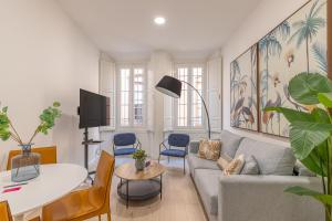 een woonkamer met een bank en een tafel bij Thyssen Boutique Apartments by Caleta Homes in Málaga